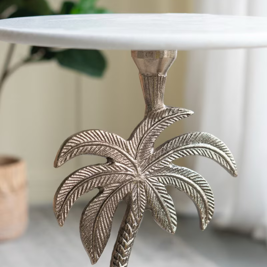 Round marble side table with a unique palm tree base design on the leg