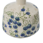 Close-up of rounded ceramic vase with hand-painted blueberry and leaf detail