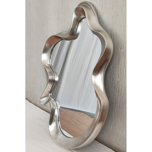 Large silver organic wavy mirror leaning against textured wall — Mish Lifestyle NZ