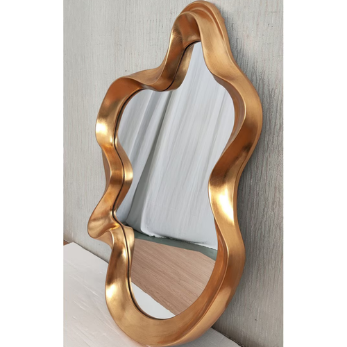 Large gold organic wavy mirror leaning against textured wall — Mish Lifestyle NZ