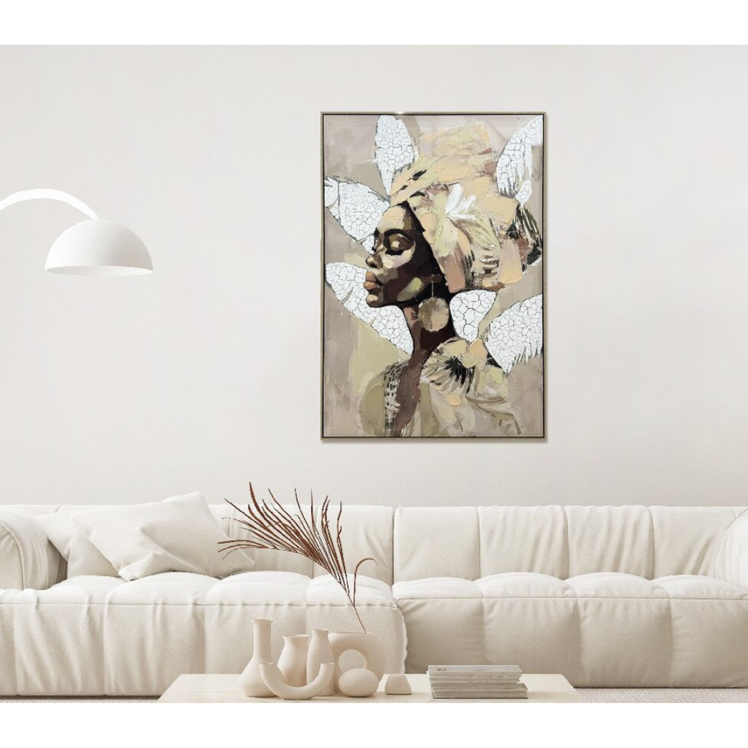Framed artwork of a stylized portrait on a wall above a white sofa.